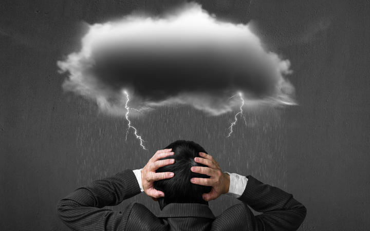 Depressed man with dark cloud rain lightning over his head.