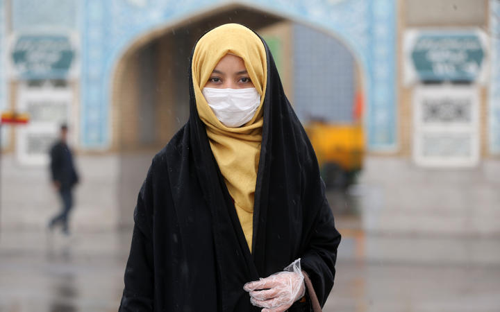 A woman wears a respiratory mask after deaths and new confirmed cases revealed from the coronavirus in Qom, Iran on February 25, 2020.