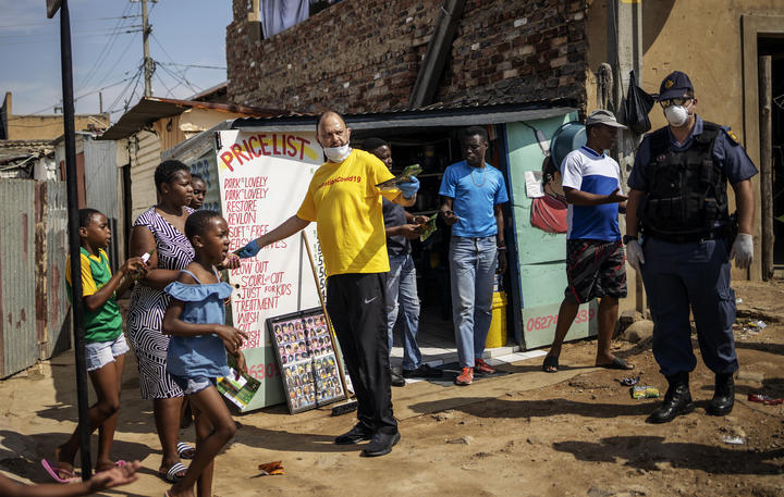 Activist Yusuf Abramjee (C) distributes soap bars amid concerns over the spread of Covid-19 coronavirus during a volunteer drive in the densely populated Diepsloot township in Johannesburg, South Africa. 