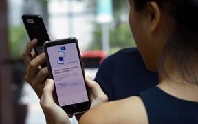 Government Technology Agency (GovTech) staff demonstrate Singapore's new contact-tracing smarthphone app called TraceTogether, as a preventive measure against the COVID-19 coronavirus in Singapore .