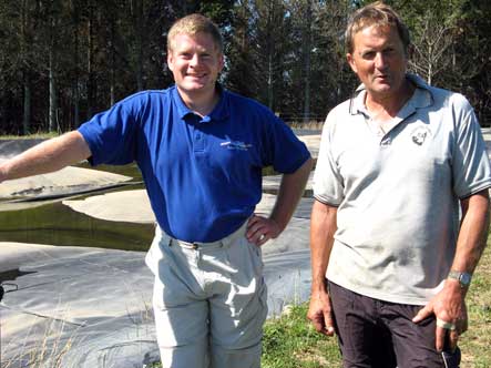 Stephan Heubeck NIWA and Steve Lepper Pig Farmer standing beside his covered anaerobic pond where collected biogas provides half the farm's electricity needs and waste hot water will heat the weaner sheds in winter. 