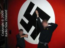 Students pose in front of a Nazi flag.