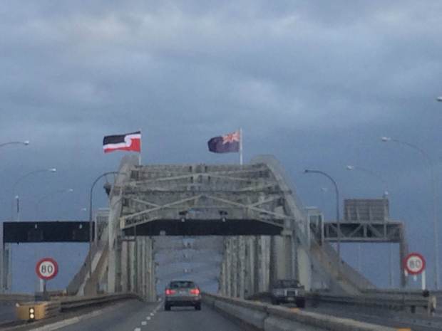 Auckland harbour Bridge flying tino rangatiratanga flag alongside New Zealand flag, Waitangi Day 2014