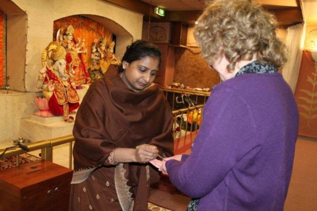 Poonam Gupta gives us offerings as part of Puja worship at the Hindu Temple