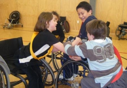 Catherine, Royden and Mike play wheelchair basketball.