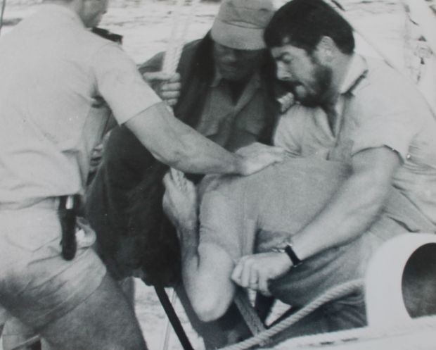 French commandoes surrounding Nigel Ingram a truncheon used to beat him can be seen in the bottom of the picture