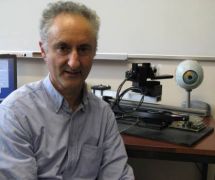 John Perrone next to a computer controlled camera set-up for studying how our eyes perceive motion