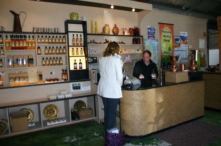 Terry and customer in his 'providor shop'. Bottles of his liquers on the walls.